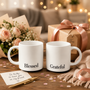 A thoughtful gift set featuring Black Blessed & Grateful Mugs, presented with a 'friend' greeting card, flowers, and a gift box in a cozy, celebratory setting.