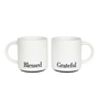 Two elegant matte white ceramic mugs stacked vertically, featuring metallic black lettering that reads 'Grateful' and 'Blessed', perfect for a minimalist and cozy home coffee aesthetic