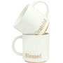 Two elegant matte white ceramic mugs stacked vertically, featuring metallic gold lettering that reads 'Grateful' and 'Blessed', perfect for a minimalist and cozy home coffee aesthetic